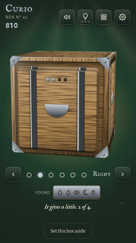 A wooden panel that gives a little with each tap, two of four taps done, with the clues found so far in a tray under the box